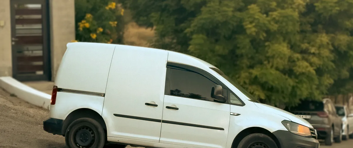 The Pet Lodge van at the gates with its side door open and a handler alongside