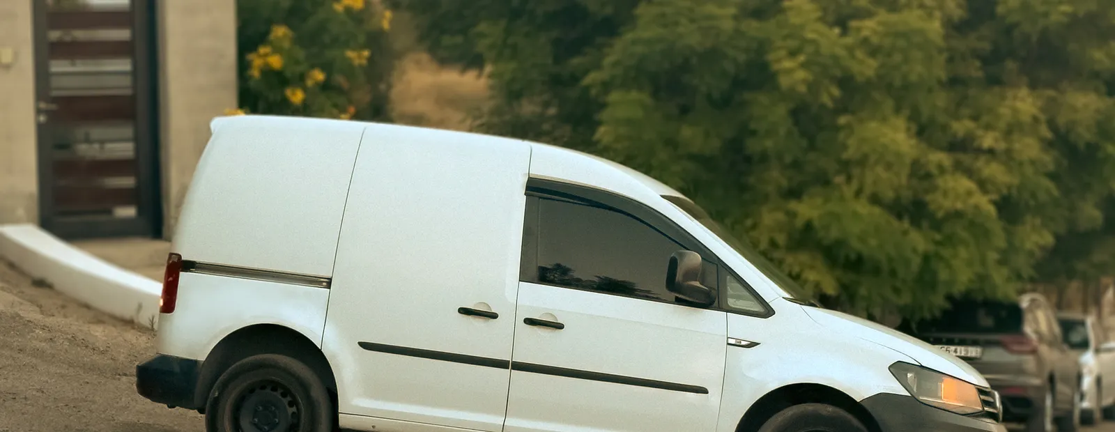 The Pet Lodge van at the gates with its side door open and a handler alongside